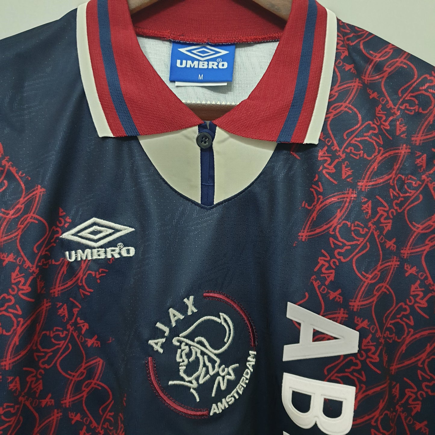 Ajax “ABN-AMRO” 1994–96 — Camiseta away Umbro azul marino (patrón rojo)