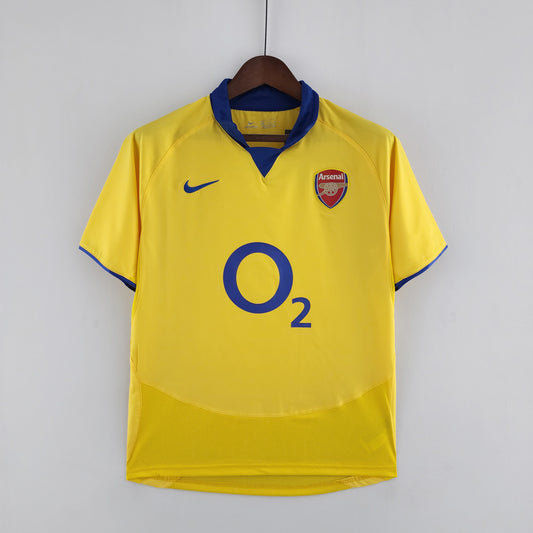 Arsenal “O2” 2004–05 — Camiseta away Nike amarilla (cuello azul)