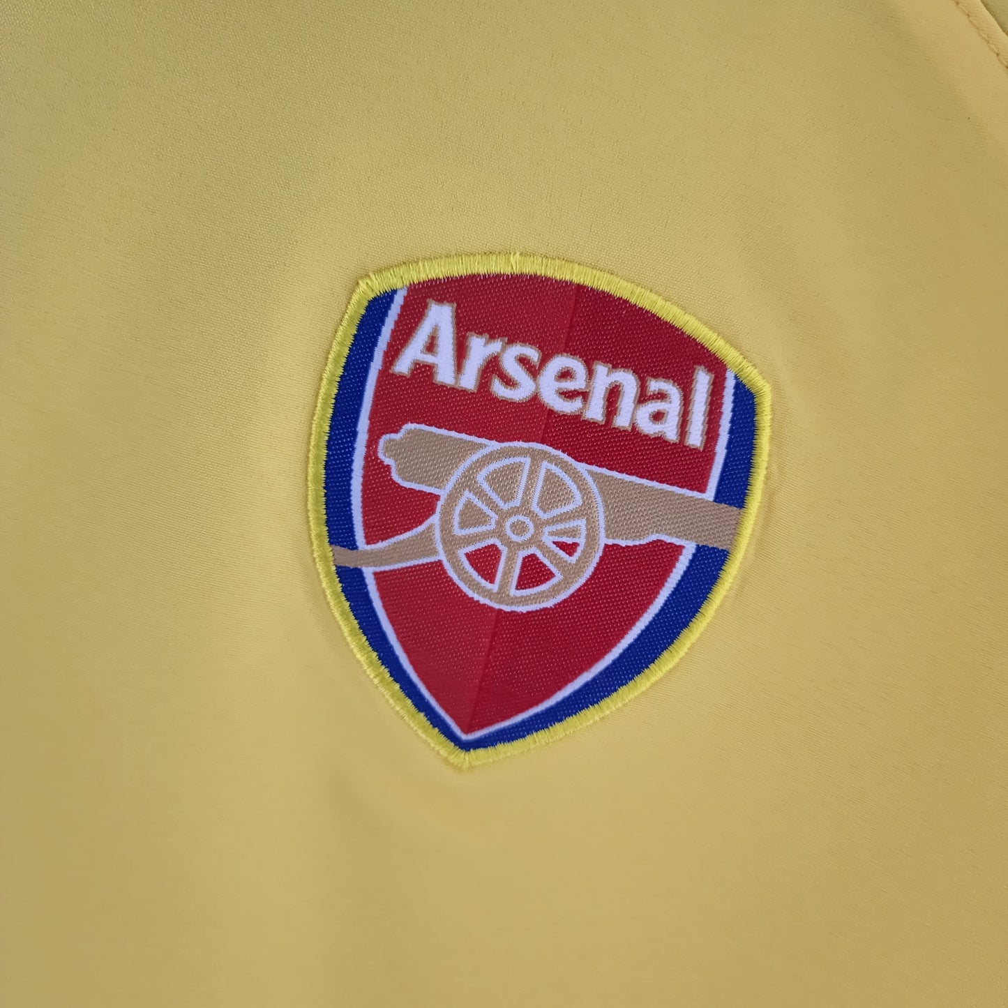 Arsenal “O2” 2004–05 — Camiseta away Nike amarilla (cuello azul)