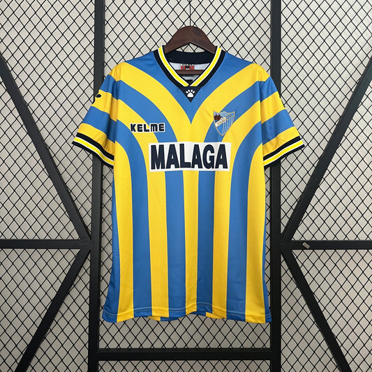 Málaga CF “MÁLAGA” 1995–97 — Camiseta home Kelme azul/amarilla (chevrón)